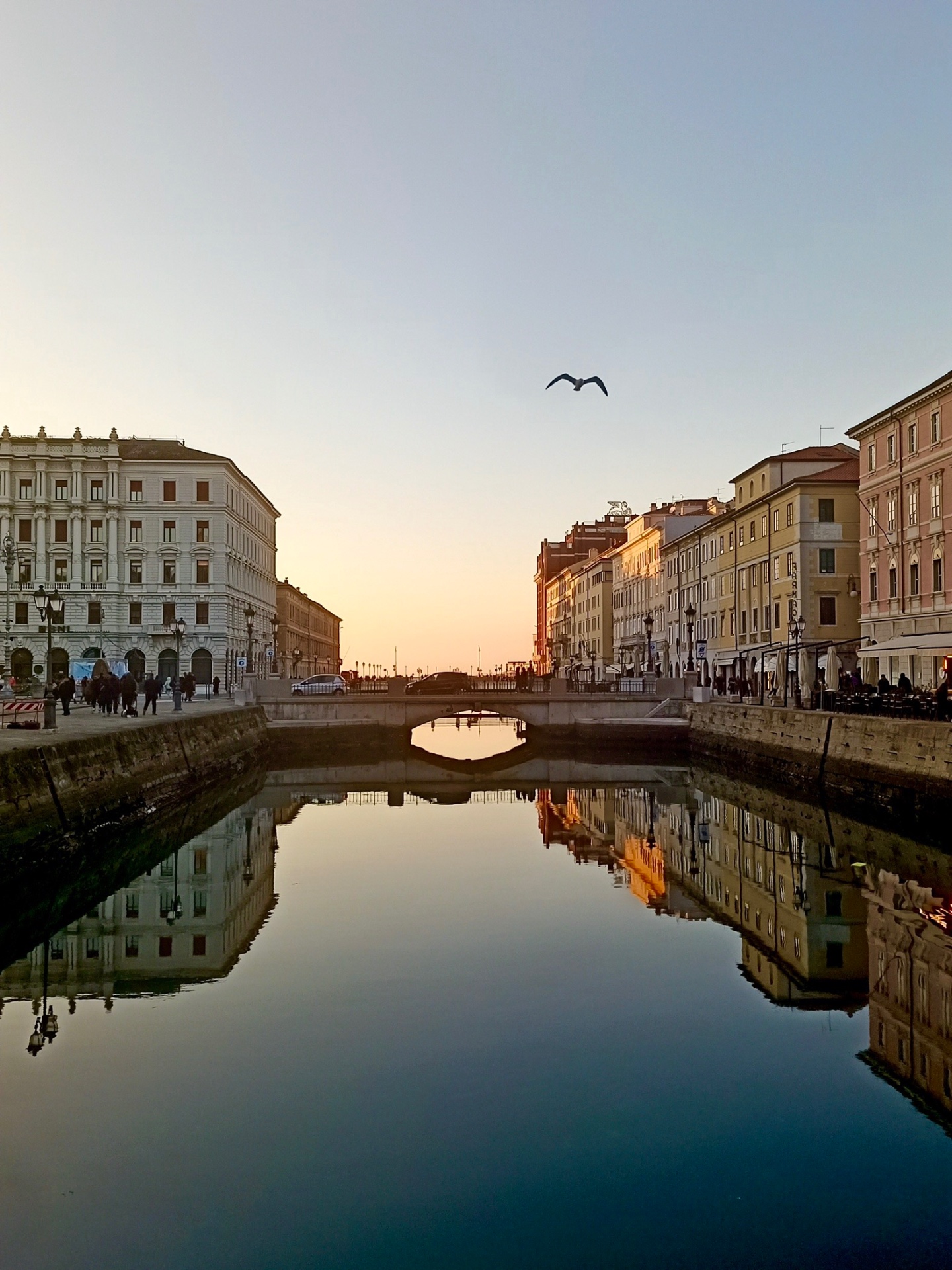 Trieste canal at sunset with historic buildings reflected in the water